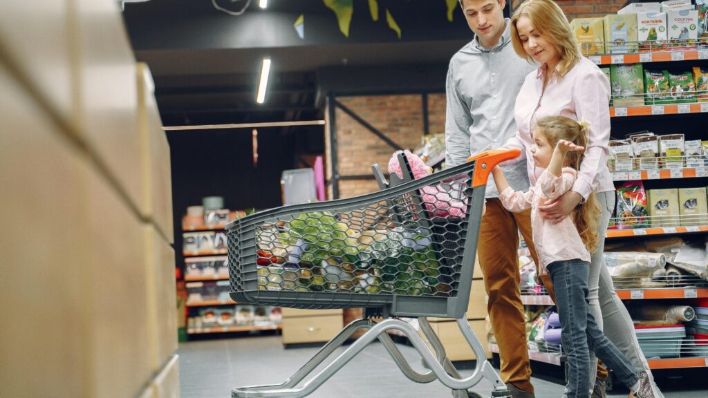 A joyful family with a child shopping together in a supermarket, bonding over groceries.